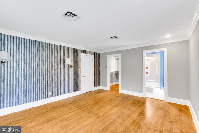 empty room featuring visible vents, baseboards, and crown molding