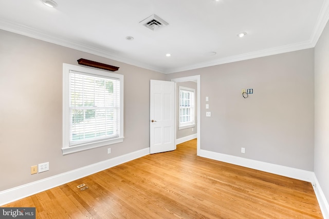 unfurnished room featuring baseboards, ornamental molding, and light wood-style flooring