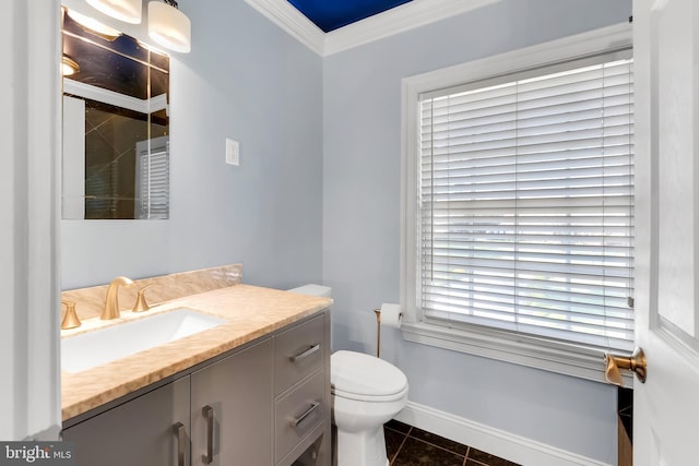 bathroom featuring tile patterned flooring, vanity, baseboards, toilet, and ornamental molding