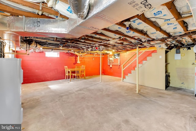basement featuring stairs and electric water heater