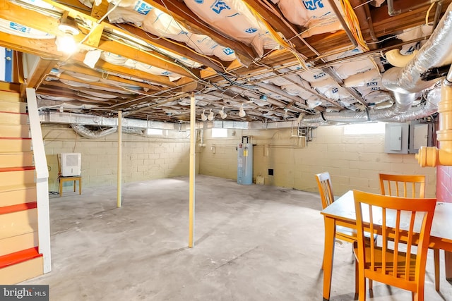 below grade area featuring a wealth of natural light, water heater, and electric panel
