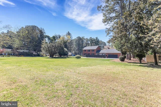 view of yard featuring fence and a garage