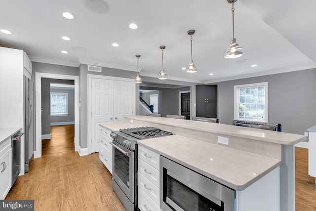 kitchen featuring crown molding, stainless steel appliances, visible vents, and plenty of natural light