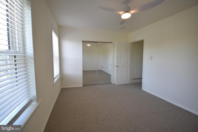 carpeted empty room featuring ceiling fan, plenty of natural light, and baseboards