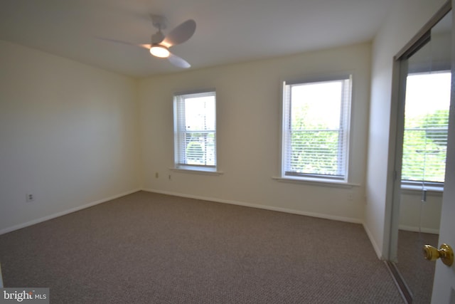 carpeted empty room with baseboards and ceiling fan