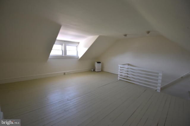 additional living space with vaulted ceiling and wood finished floors