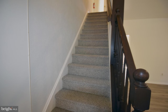 stairs featuring baseboards and wood finished floors