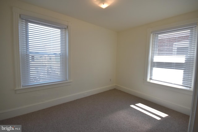 carpeted spare room with baseboards