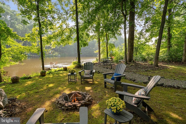 surrounding community featuring a water view, a boat dock, and a fire pit