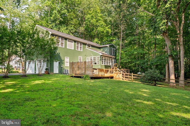 back of property featuring a yard, fence, and a wooden deck