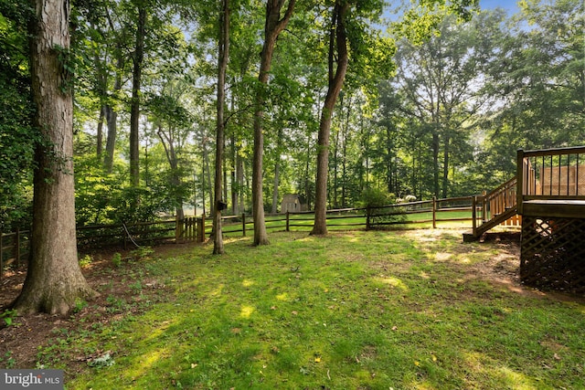 view of yard featuring a fenced backyard, a deck, and stairway