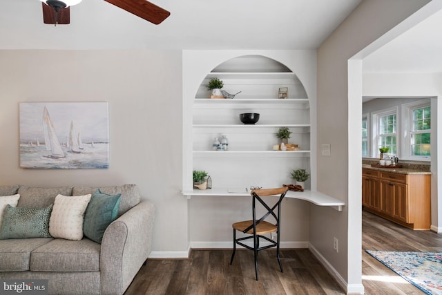 living area featuring dark wood-type flooring, baseboards, and ceiling fan