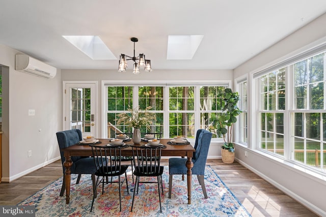 interior space featuring a healthy amount of sunlight, an inviting chandelier, a wall unit AC, and a skylight