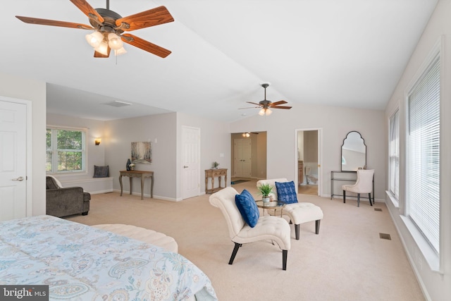 bedroom with lofted ceiling, light colored carpet, ensuite bath, visible vents, and baseboards