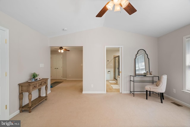 living area featuring ceiling fan, lofted ceiling, light colored carpet, and visible vents