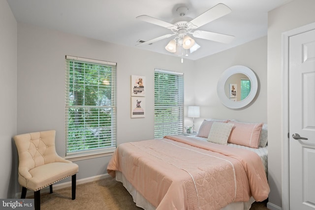 bedroom featuring ceiling fan, carpet flooring, baseboards, and multiple windows