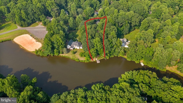 bird's eye view featuring a wooded view and a water view