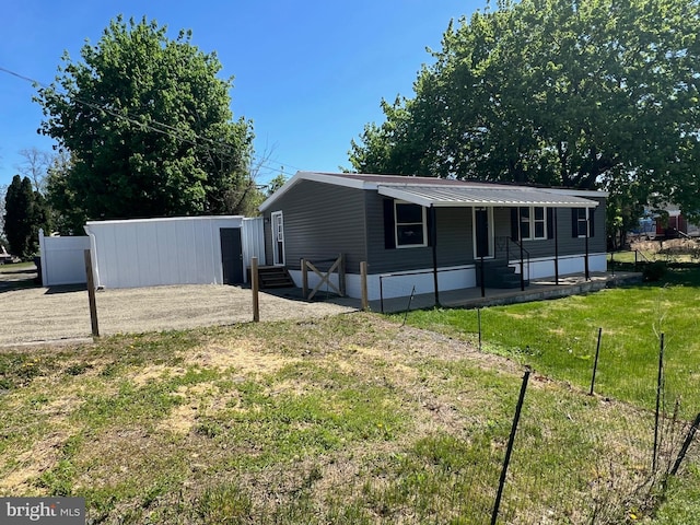 exterior space featuring fence, entry steps, and a front lawn