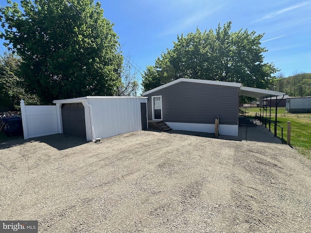 view of front of home with entry steps, an outdoor structure, driveway, and a garage
