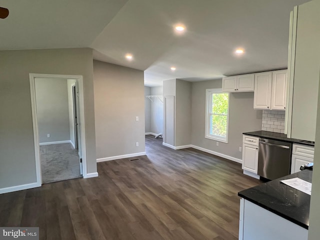kitchen with dark wood-style flooring, dark countertops, dishwasher, baseboards, and white cabinets
