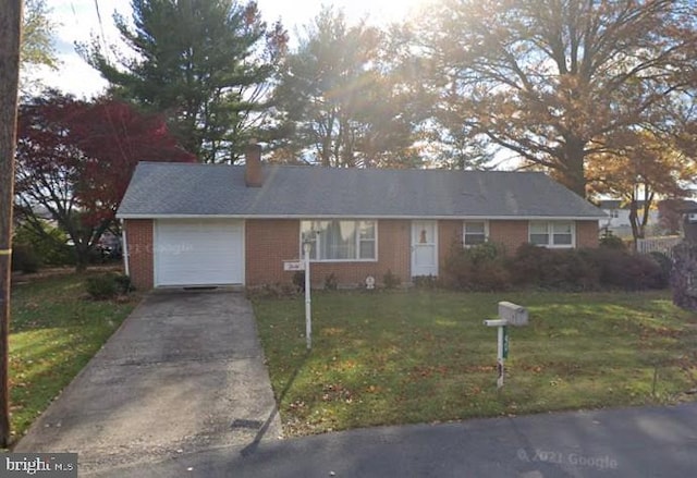 single story home featuring a chimney, a garage, brick siding, a front lawn, and concrete driveway