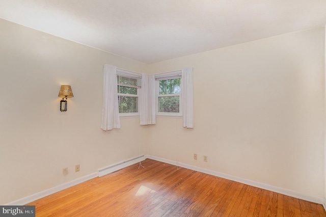 spare room featuring baseboards, light wood-style floors, and baseboard heating