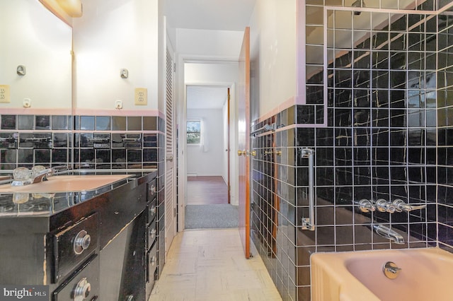 bathroom featuring vanity and tile walls