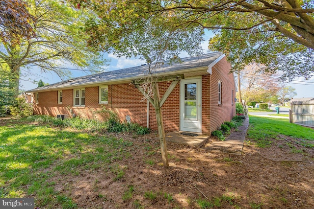 back of property with brick siding and a lawn