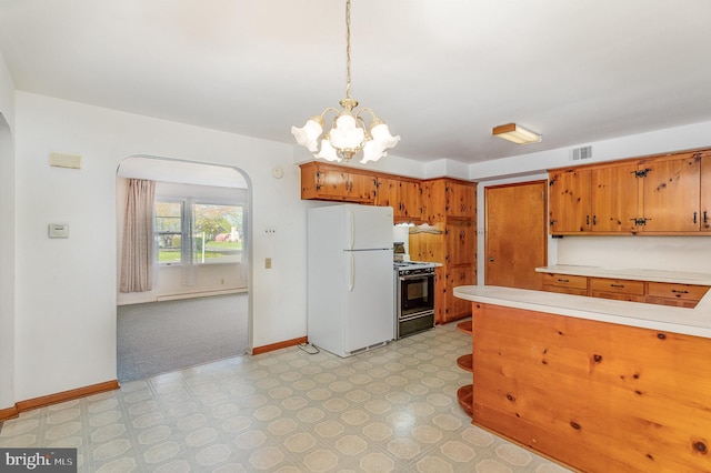 kitchen featuring freestanding refrigerator, baseboards, light countertops, range with gas cooktop, and arched walkways
