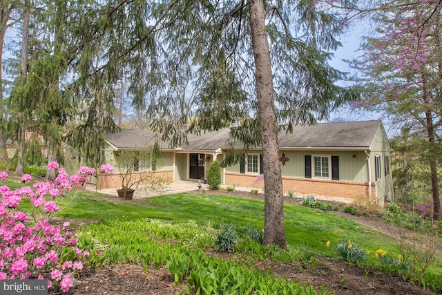 view of front of house with brick siding and a front yard