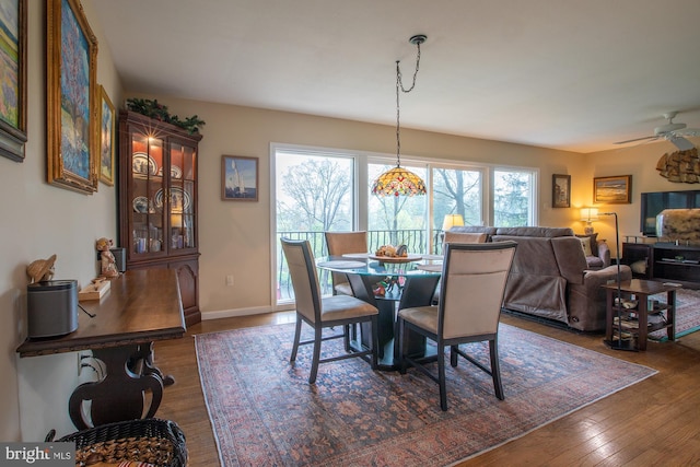 dining area with ceiling fan, dark wood-style floors, and baseboards