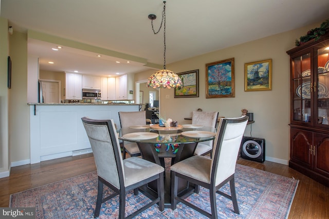dining area featuring recessed lighting, dark wood finished floors, and baseboards
