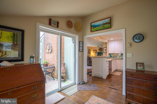 doorway featuring lofted ceiling and light tile patterned flooring