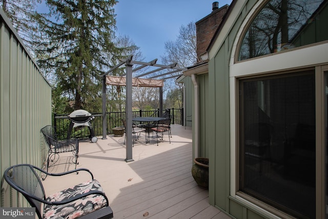 wooden terrace with outdoor dining area and a pergola
