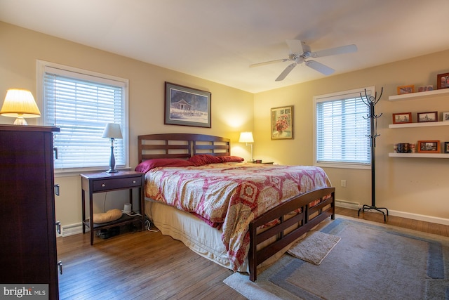 bedroom featuring baseboards, multiple windows, and hardwood / wood-style flooring