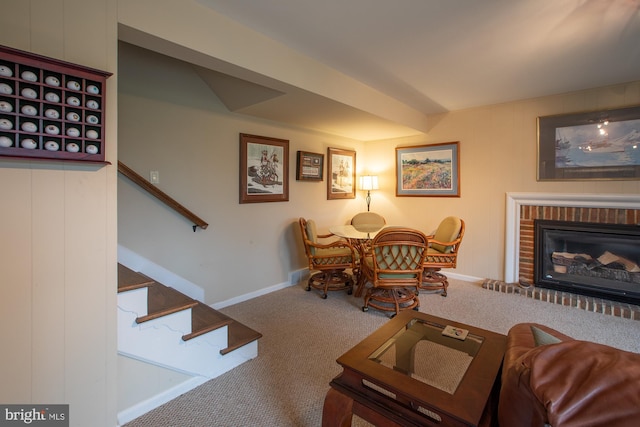living area featuring stairway, carpet floors, baseboards, and a fireplace
