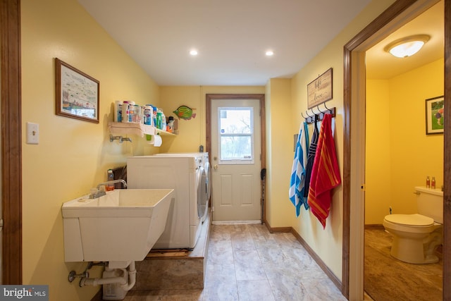 laundry room featuring separate washer and dryer, recessed lighting, and a sink