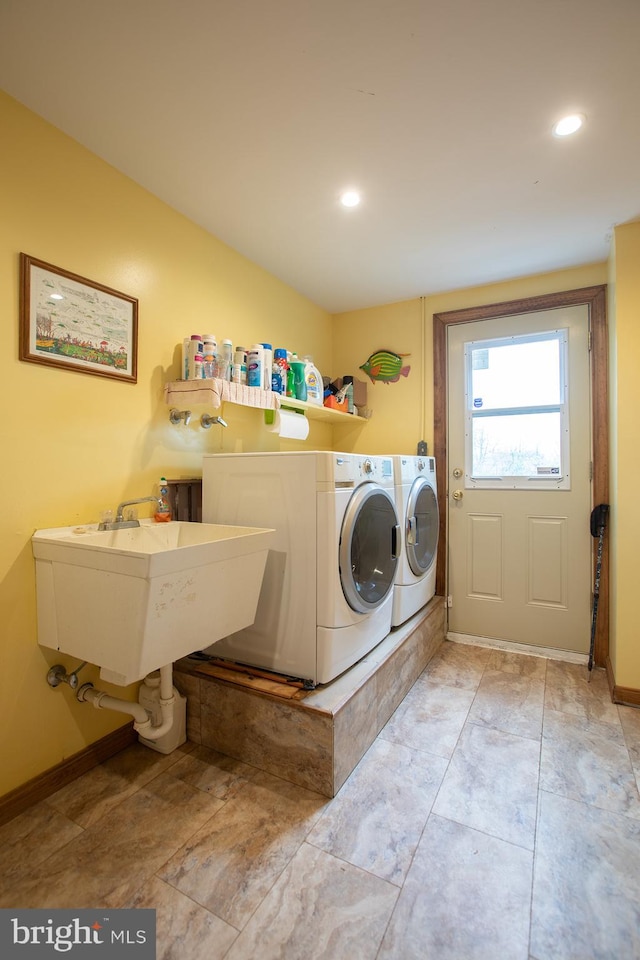 laundry room with laundry area, baseboards, recessed lighting, washer and clothes dryer, and a sink