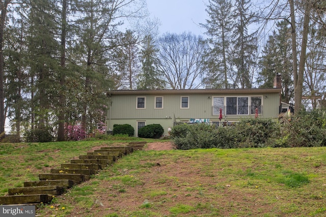 back of property featuring a yard and a chimney