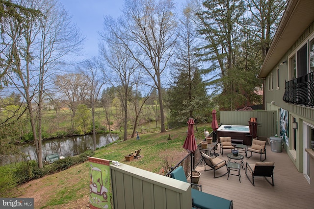 wooden deck featuring an outdoor living space, a water view, and a hot tub
