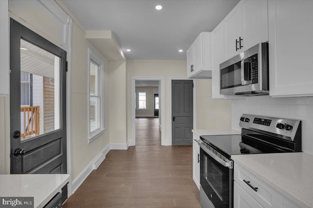 226 W Franklin St, Womelsdorf, PA 19567 - kitchen with dark wood-style floors, decorative backsplash, baseboards, white cabinets, and appliances with stainless steel finishes