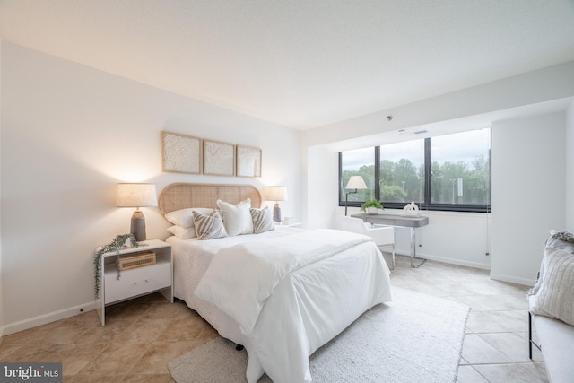 bedroom with light tile patterned floors and baseboards