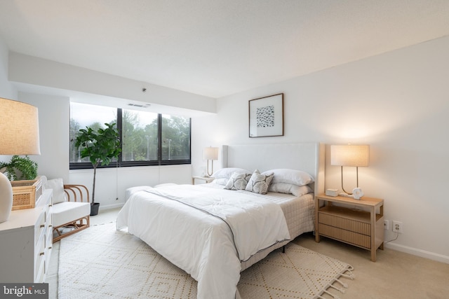 bedroom featuring baseboards, visible vents, and light carpet