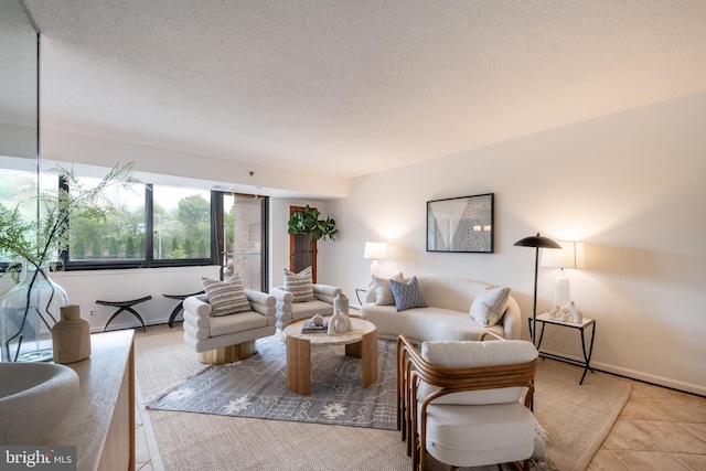 living room featuring baseboards, a textured ceiling, and tile patterned flooring