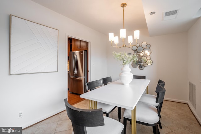 dining space featuring baseboards, visible vents, a notable chandelier, and light tile patterned flooring