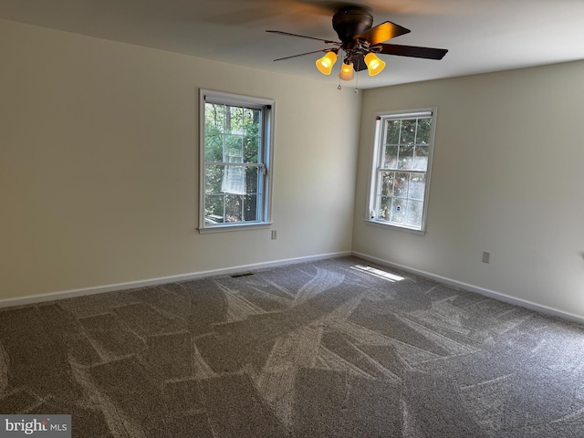 spare room featuring baseboards, ceiling fan, and a healthy amount of sunlight