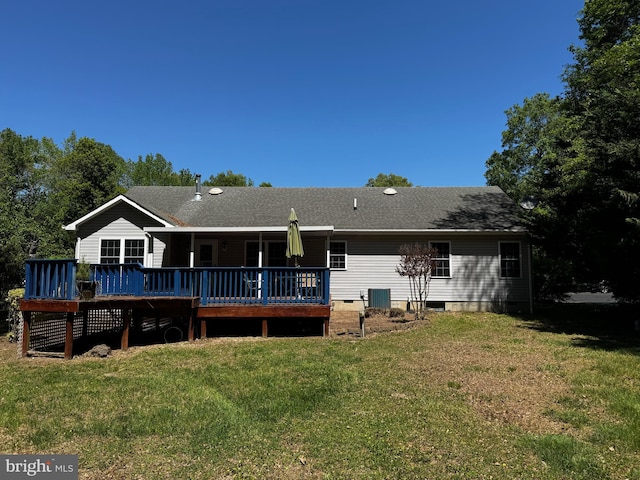 rear view of house featuring a lawn, central AC unit, a wooden deck, and a shingled roof