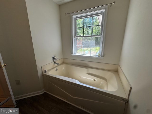 full bathroom featuring baseboards, plenty of natural light, a garden tub, and wood finished floors