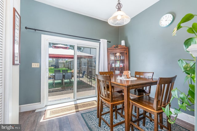 dining area with baseboards and wood finished floors