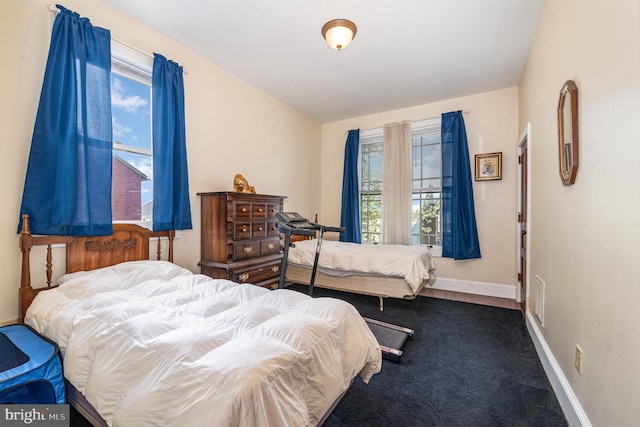 bedroom with baseboards and carpet
